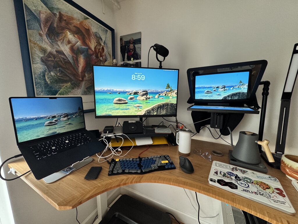 My desk setup: mirrorless camera and teleprompter mounted above a monitor, with microphone and desk organizers